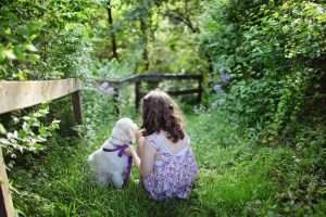 flicka och hund i trädgården